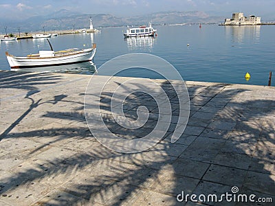 Boats in mediterranean port and palm shadow, NAFPLIO, GREECE Stock Photo